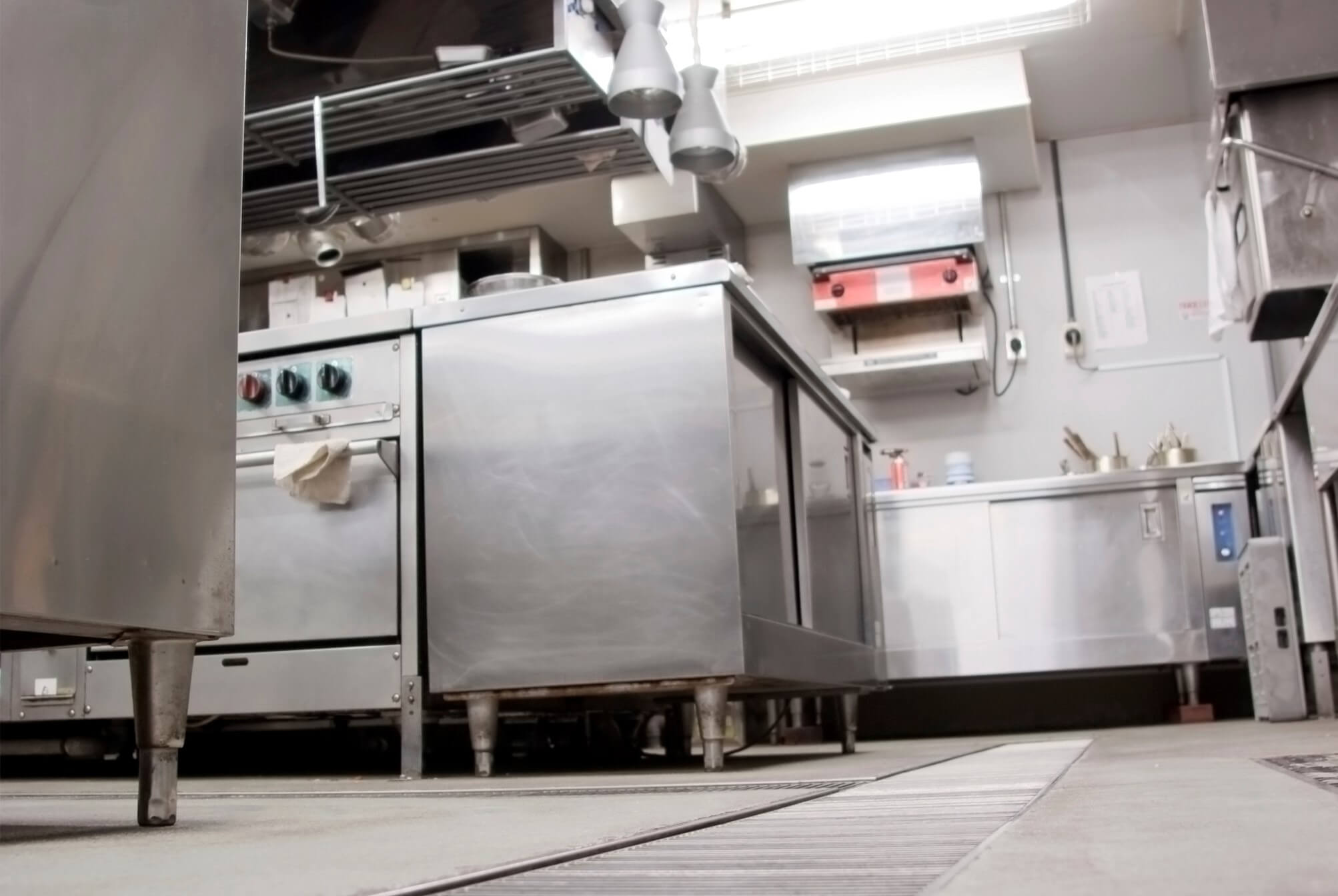Inside an empty commercial restaurant kitchen, a view from the floor.